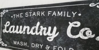 Photo of the Stark Family Laundry Co sign in distressed black paint