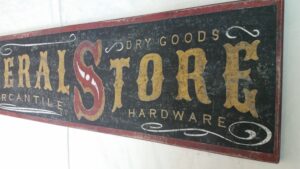 Close-up of the General Store Sign example with a rustic black background and gold lettering