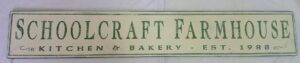 The Schoolcraft farmhouse wood sign in antique white with forest green letters