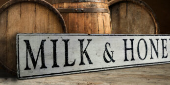 Milk and Honey wood sign on an off white antique painted board.