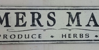 The original Farmers Market sign, with Fresh Produce Herbs Flowers lettering underneath.