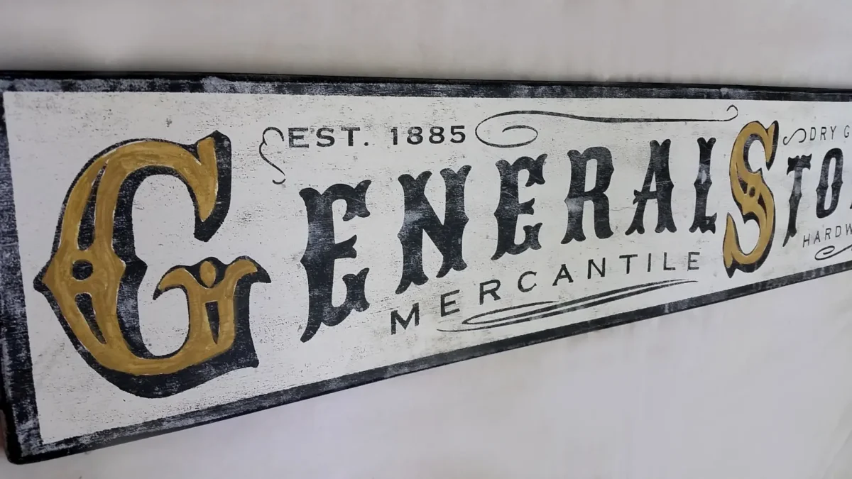 Detailed view of rustic General Store sign showcasing distressed lettering and wood texture