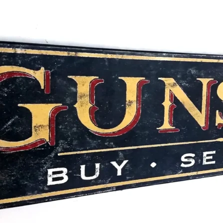 Closeup view of gold lettering and distressed finish on a gunsmith sign