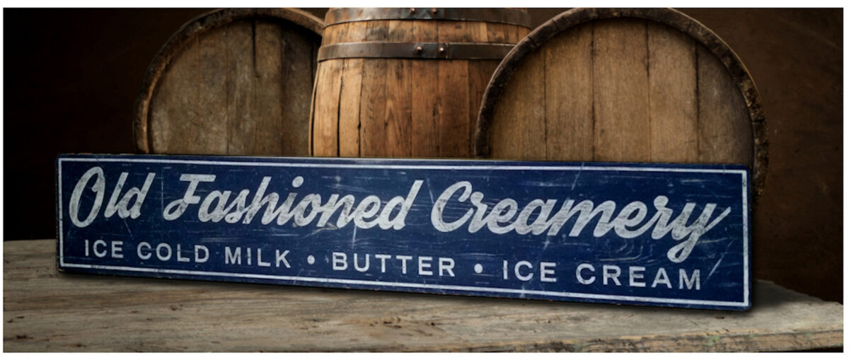 Old Fashioned Creamery Sign in English blue paint with white letters.