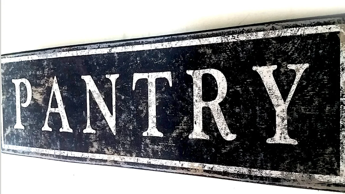 Closeup view of the distressed finish on a wooden pantry sign