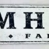 Antique-style farmhouse sign with distressed white background and black letters