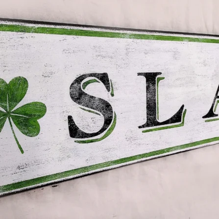 Closeup view of antique Sláinte sign showcasing distressed details and shamrocks