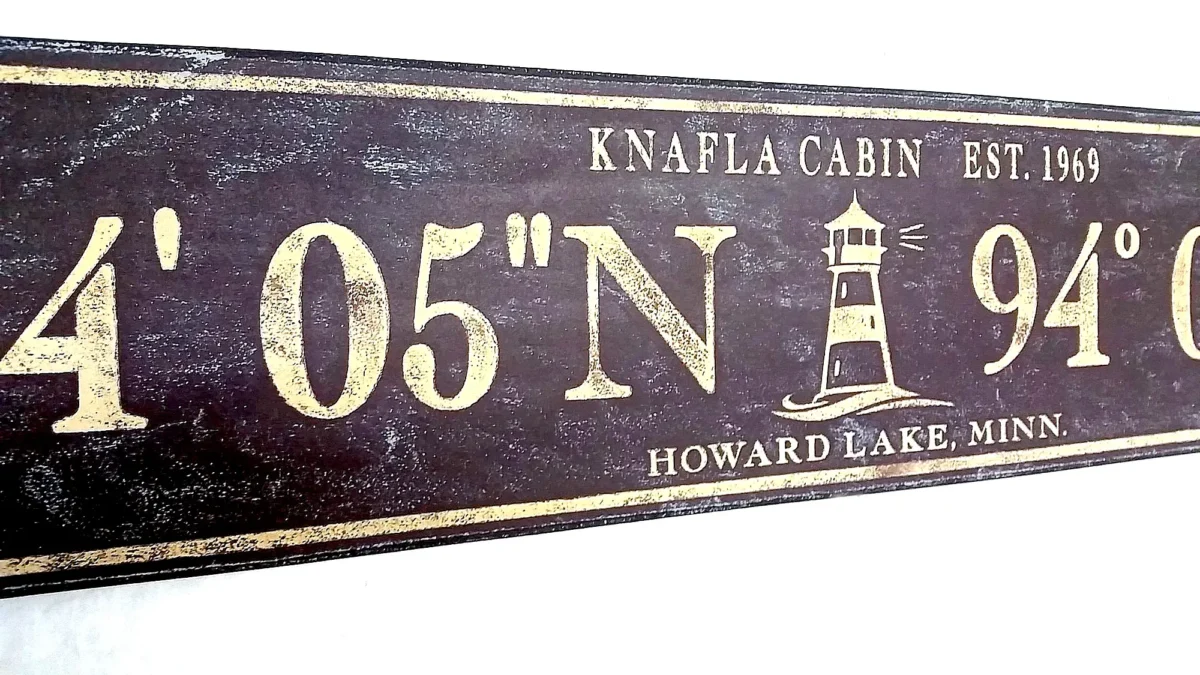 Closeup of antique wood sign with lighthouse and personalized coordinates