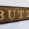 Closeup view of antique Buttery sign highlighting gold lettering and details