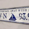 Closeup view of the antique style coordinate sign showcasing bold navy blue letters on a white distressed background.