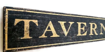 Closeup view of antique gold letters on a rustic tavern sign