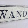 Closeup view of antique Wanderlust sign showcasing detailed craftsmanship